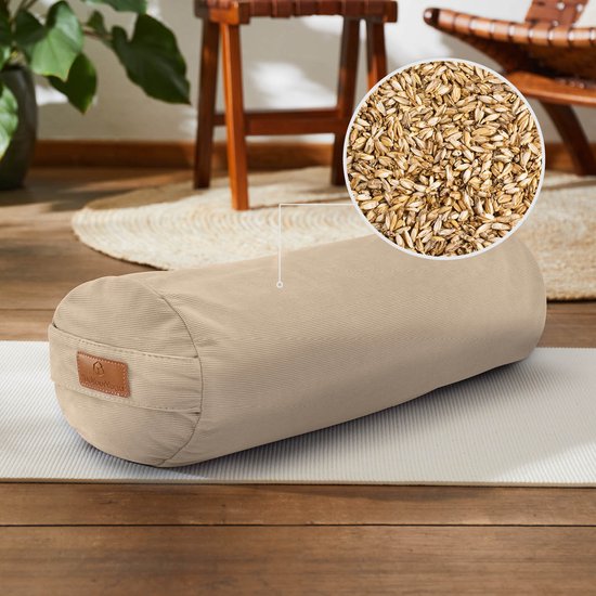 Beige corduroy yogabolster op een yogamat, met een ingezoomde afbeelding van speltkaf.
