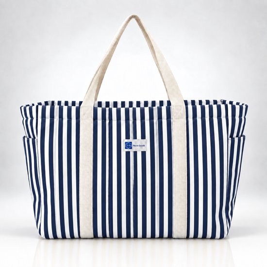 Blauw-wit gestreepte strandtas van Heuts Goods met beige hengsels en een label.