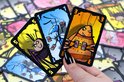 Een hand met drie kaarten uit het spel Valse Motten