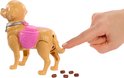 Een hand raakt de staart aan van een bruine speelgoedhond met een roze zadel en halsband. Er liggen bruine brokken op de grond.