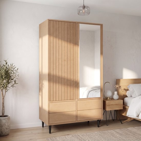 Houten kledingkast met geribbelde deur, spiegel en vier lades, in een slaapkamer met veel zonlicht.