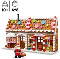 Een LEGO peperkoekhuis met kerstman, met een façades met snoepstokken, roze accenten en veelkleurige raampjes. Er staat "9083" op het postkantoor.