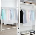Twee kledinghoezen over kleding, de linker op een staand rek, de rechter in een kast.