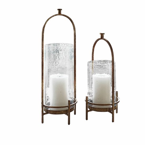 Set van twee glazen windlichten met een antiekbronskleurig, gebogen metalen frame.