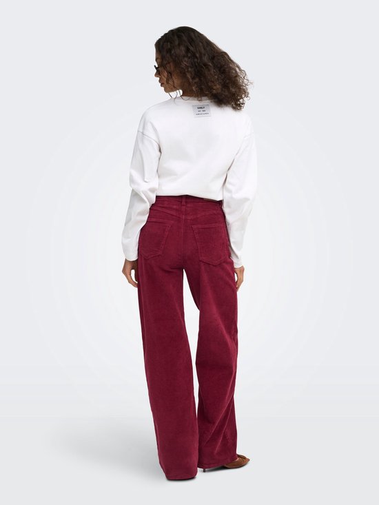 Model van achteren gezien in bordeauxrode corduroy broek met wijde pijpen en witte top.