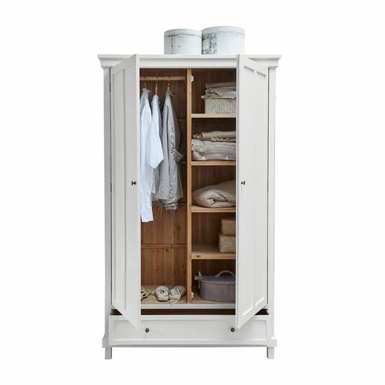 Open witte kledingkast met hangende kleding, opgevouwen spullen en manden op planken.