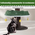 Kat krabt aan de sisalstam van de kerstboom-krabpaal.