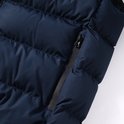 Detail van de ritssluiting op de zak van de donkerblauwe gewatteerde bodywarmer.