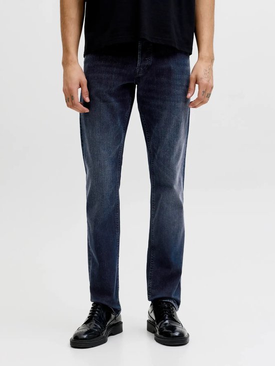 Man met een zwart t-shirt en blauwe jeans.