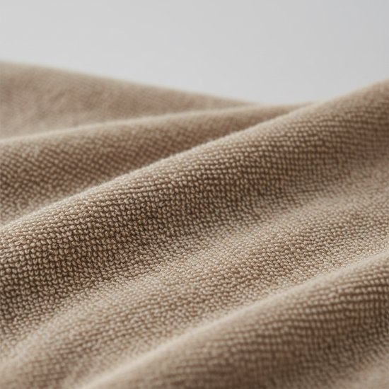 Tissu éponge taupe avec une texture fine et des plis ondulés.