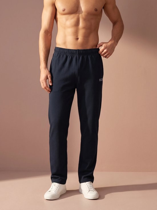 Man met donkerblauwe sportbroek en witte sneakers.