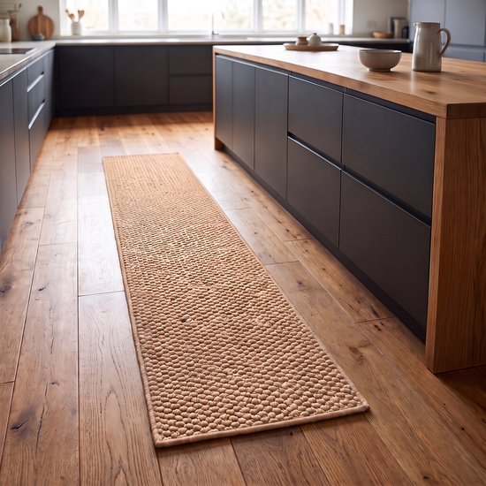Un tapis de cuisine beige à poils courts avec une texture de petites boules rondes, posé sur un plancher en bois dans une cuisine moderne.