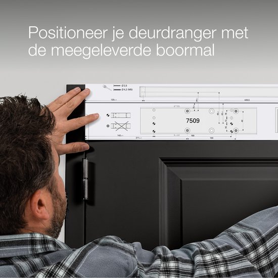Man plaatst een boormal op een zwarte deur om deurensluiting te monteren.