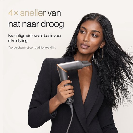 Vrouw met nat donker haar, met een grijze föhn met gouden accenten.
