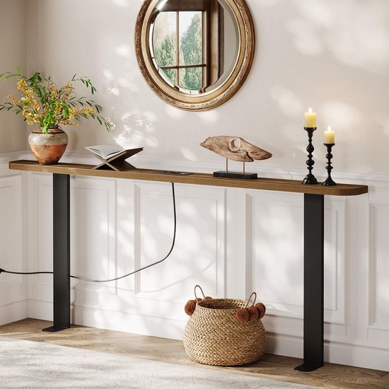 Houten console-tafel tegen een muur met zwarte poten, decoraties en een mand met pompons op de vloer.