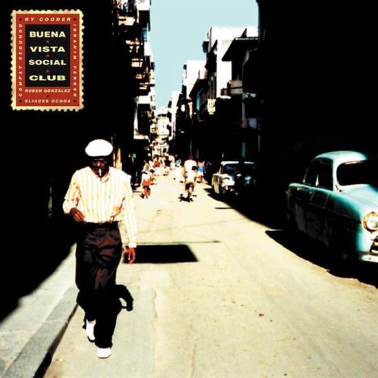 Hoes van Buena Vista Social Club met een man in gestreept hemd en witte pet die door een Cubaanse straat loopt.