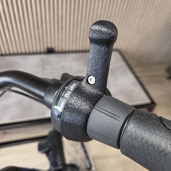 Ergonomische 3D-geprinte schakelhulp gemonteerd op het zwarte handvat van een fiets met Shimano Nexus versteller.