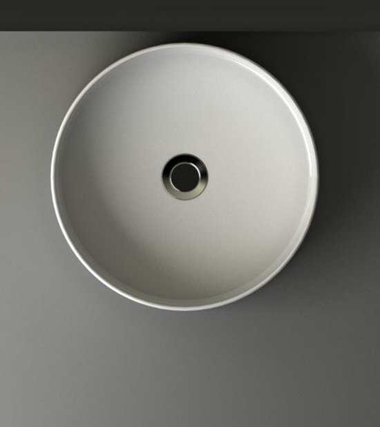 Bovenaanzicht van een ronde, witte opzetwastafel met een centraal afvoergat.
