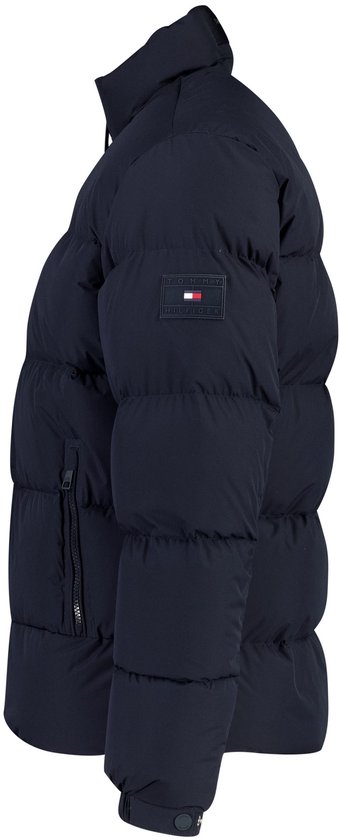 Donkerblauwe gewatteerde jas met opstaande kraag en Tommy Hilfiger-logo op de linkermouw.