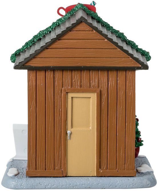 Achterkant van een houten Lemax-kraam met een lichtgekleurde deur en een besneeuwd dak met kerstversiering.