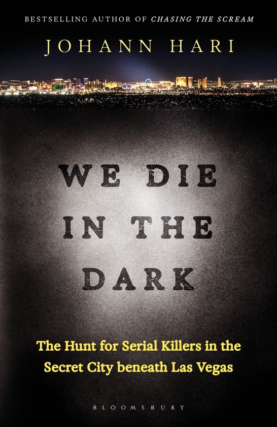 Boekcover "We Die In The Dark" van Johann Hari. Met op de voorgrond de titel in grote letters en op de achtergrond een nachtelijke stadsverlichting.