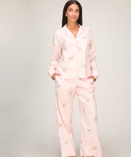 Model draagt een roze pyjamaset met een print van kleine herten.