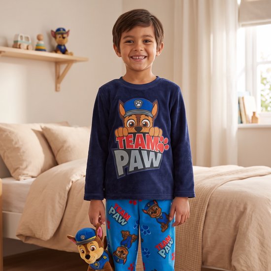 Jongen draagt marineblauwe Paw Patrol fleecepyjama met 'TEAM PAW' print en houdt een Chase-knuffel vast.
