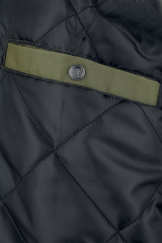Detail van de zwarte, gewatteerde voering met een olijfgroene zakopening en een metalen knoop.