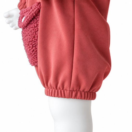 Close-up van de elastische onderkant en de zachte teddy-buidelzak van een roze baby-romper.
