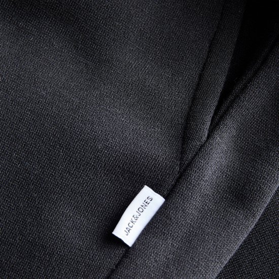 Detail van zwarte sweatstof met een wit JACK&JONES label.