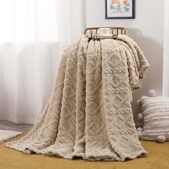 Beige plaid met diamant- en golfpatroon, textuur met reliëf, gedrapeerd over een stoel.
