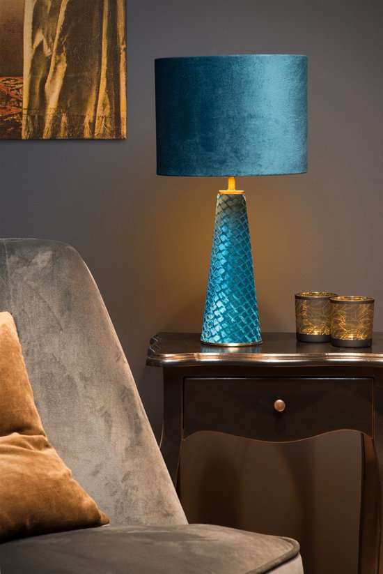 Turquoise fluwelen lampenkap bovenop een smalle, turquoise lampenvoet met een visnetpatroon.
