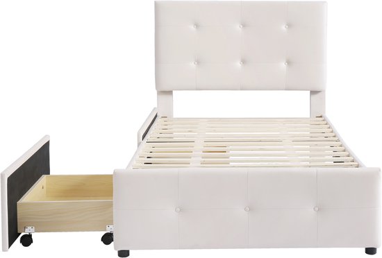Beige gestoffeerd eenpersoonsbed met open opberglade, knoppen op hoofdeinde en bedframe.