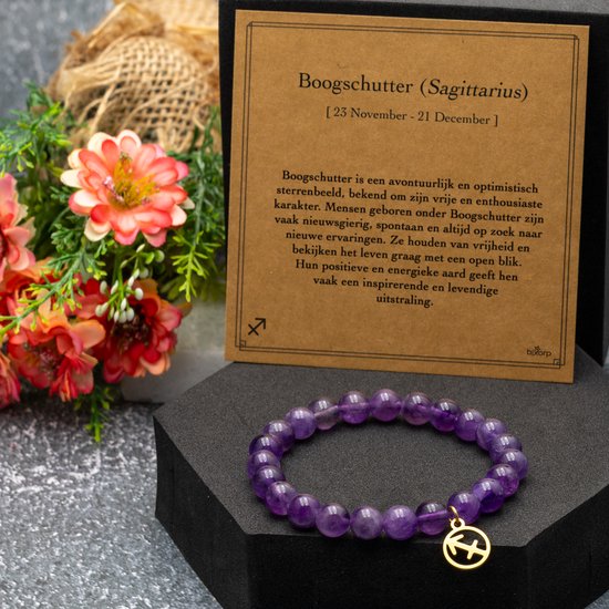 Amethist edelsteen armband met gouden Sagittarius bedel, naast een kaart met astrologische informatie.