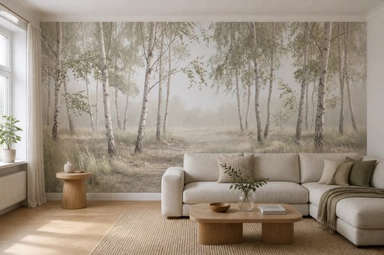 Papier peint représentant une forêt de bouleaux dans le brouillard, avec un canapé et des meubles au premier plan.
