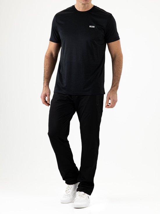 Man in een gestreepte zwarte T-shirt en een zwarte trainingsbroek van Sjeng Sports.