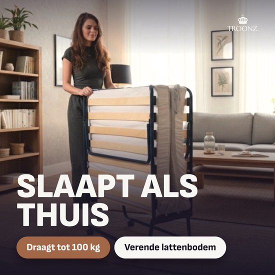 Vrouw naast een opgeklapt Troonz logeerbed met verende houten lattenbodem.