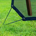 Zwart net met elastische koorden die aan een houten paal bevestigd zijn, op gras.