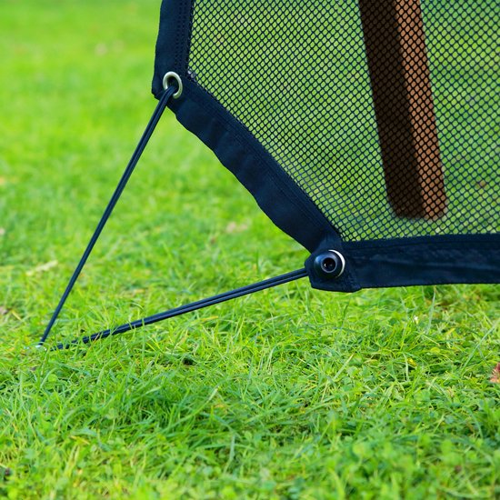 Zwart net met elastische koorden die aan een houten paal bevestigd zijn, op gras.