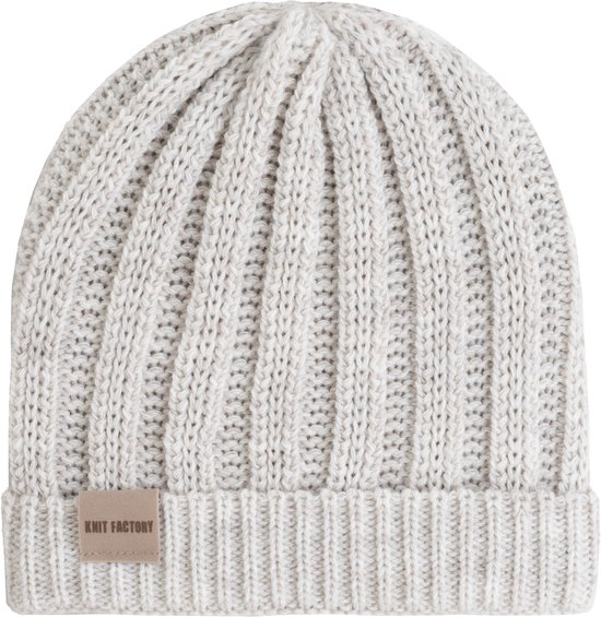 Off-white gebreide muts met ribbelstructuur en een beige label met 'KNIT FACTORY'.