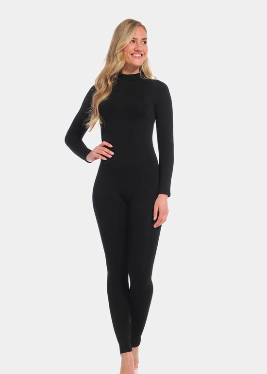 Model met blonde haren, draagt een zwarte jumpsuit met lange mouwen, rechterhand op de heup.