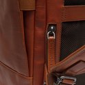 Detail van een cognac leren rugzak met ritssluiting en een leren lipje met 'The Chesterfield Brand' erop.