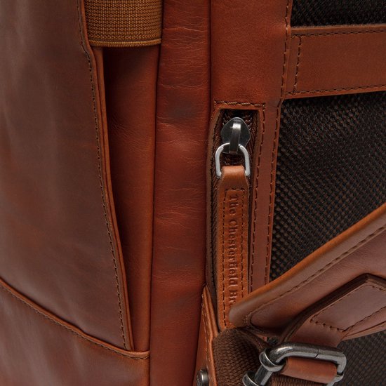 Detail van een cognac leren rugzak met ritssluiting en een leren lipje met 'The Chesterfield Brand' erop.