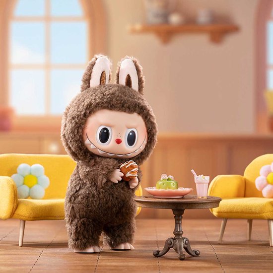 Bruin pluizig figuurtje in konijnenkostuum dat een koekje vasthoudt bij een tafel met taart.