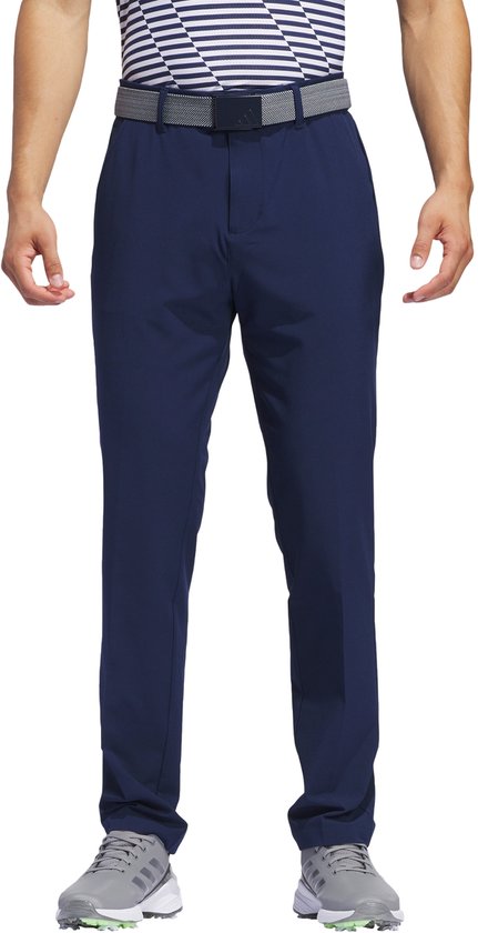 Man in een donkerblauwe golfbroek en gestreept shirt.