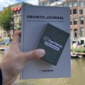 Hand houdt groen doosje 'Reflectiekaarten' voor een 'Growth Journal'.