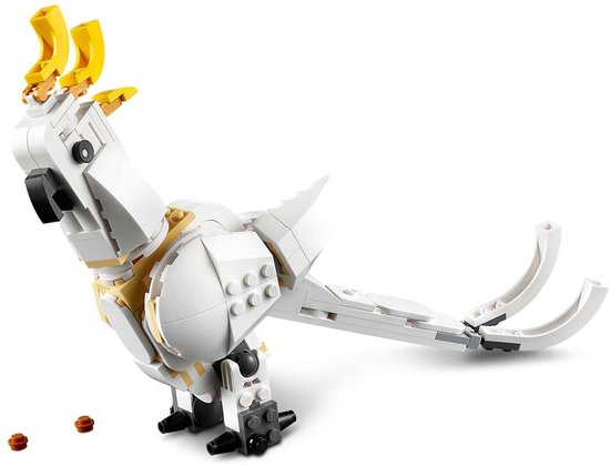 Un cacatoès LEGO blanc avec une crête jaune et des graines brunes.