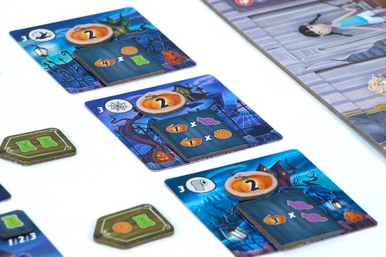 Griezelige spelkaarten met huizen en pompoenen, en groene berensnoepjes van Tricky Treats.