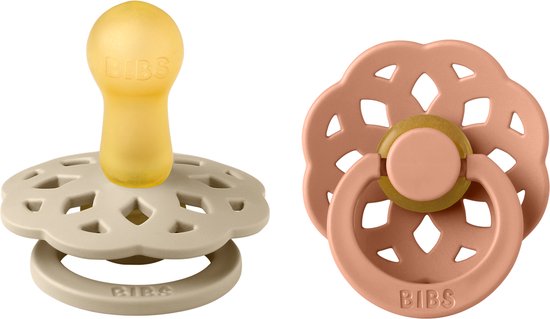 Twee BIBS fopspenen: één beige met bloemvormig schild, één perzik met bloemvormig schild.