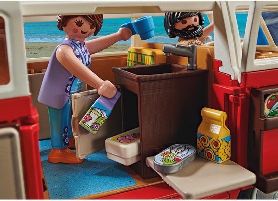 Interieur van een PLAYMOBIL camperbus met twee figuren die uitpakken, met een gootsteen en eten.